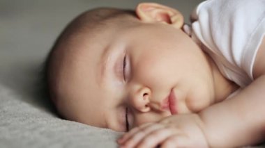 Gri battaniyenin üzerinde uyuyan tatlı çocuk.