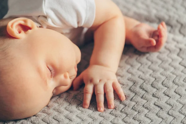 Mano de bebé durmiendo de cerca en la cama — Foto de Stock