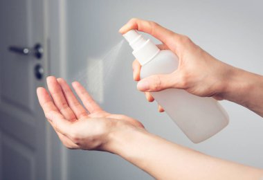 Bakteri, bakteri ve virüsün yayılmasını önlemek için alkol spreyi ya da anti bakteri spreyi kullanan kadın eller.