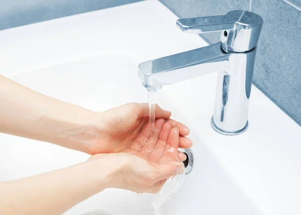 Donna utilizzare acqua e lavarsi le mani sotto il rubinetto dell'acqua — Foto Stock