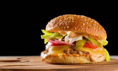 Köfteli, peynirli, domatesli, turşulu, soğanlı, marullu ve soslu klasik hamburger.