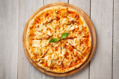Tahta kesme tahtasında tavuk ve ananaslı lezzetli Hawaii pizzası. Üst görünüm