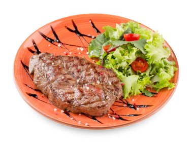 Salata, domates ve soslu ızgara biftek. Beyaz üzerine izole edilmiş portakal tabağı.
