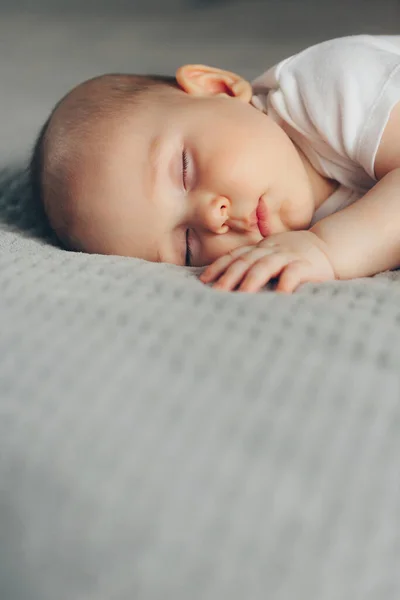 Dormir bebé niño en traje de cuerpo blanco en la cama con copyspace — Foto de Stock