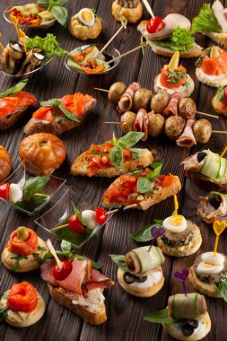 Ahşap arka planda farklı atıştırmalıklar ve aperatifler. Güzel yemek sofrası..