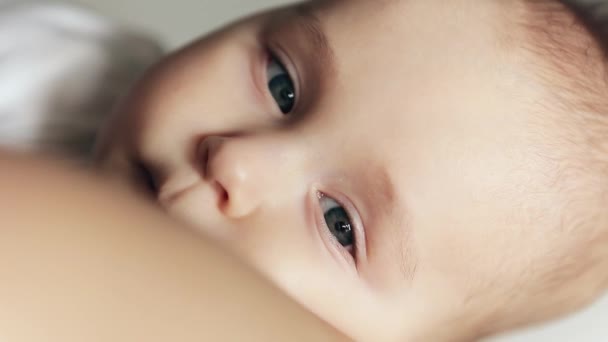 Retrato de cerca del tranquilo niño somnoliento en brazos maternos. Bebé mirando a la cámara . — Vídeos de Stock