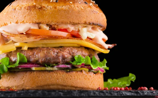 Primo piano Hamburger gustoso con manzo, pomodoro, sottaceto, cipolla, lattuga e salsa — Foto Stock