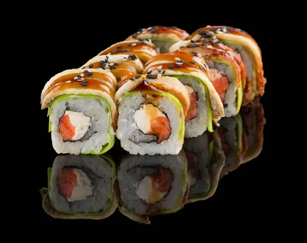 Sushi roll with salmon, cheese, avocado, eel, unagi sauce and sesame isolated on black background with reflection — Stock Photo, Image