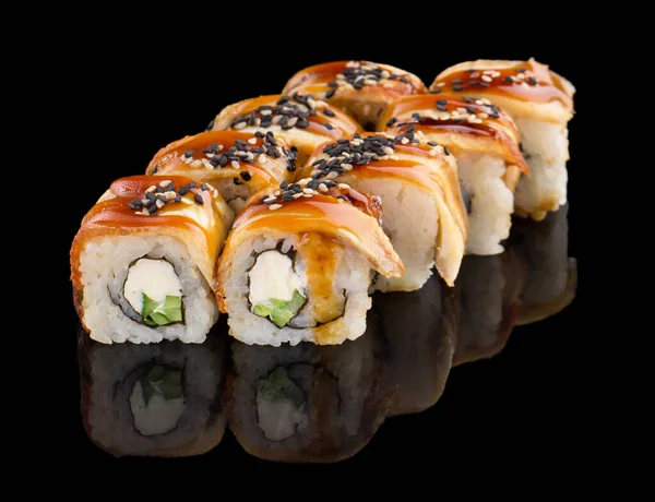 Sushi roll with eel, cheese, cucumber, unagi sauce and sesame isolated on black background with reflection — Stock Photo, Image