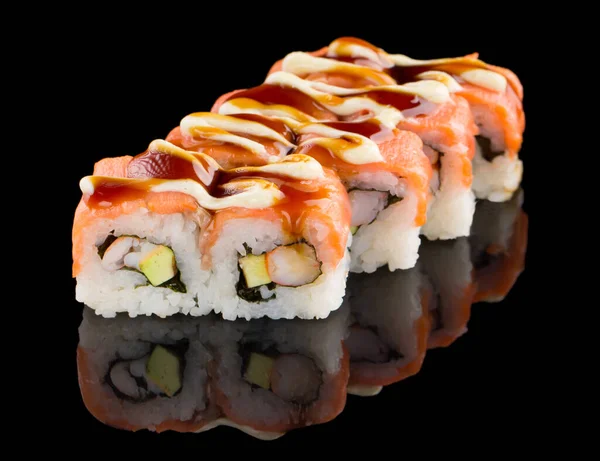 Sushi roll with salmon, shrimp, avocado and sauce isolated on black background with reflection — Stock Photo, Image