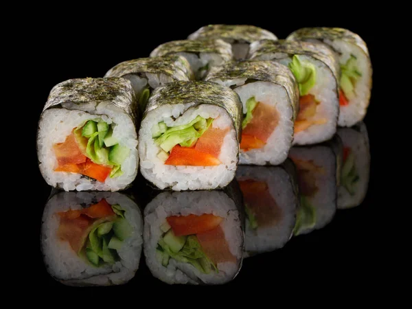 Χορτοφαγικό ρολό σούσι με λαχανικά: πιπέρι, αγγούρι, αβοκάντο και σαλάτα που απομονώνονται σε μαύρο φόντο με αντανάκλαση — Φωτογραφία Αρχείου