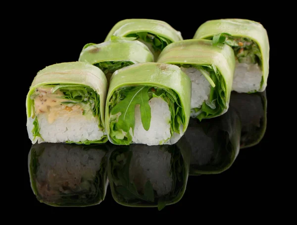 Rollo de sushi vegetariano con rúcula, aguacate y salsa de nueces aislados sobre fondo negro con reflexión — Foto de Stock