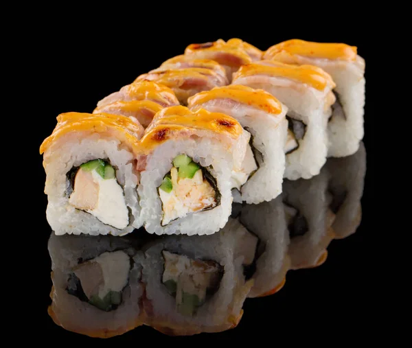 Hot Sushi Uramaki rolo com salmão, enguia, queijo, pepino e molho isolado em fundo preto com reflexão — Fotografia de Stock