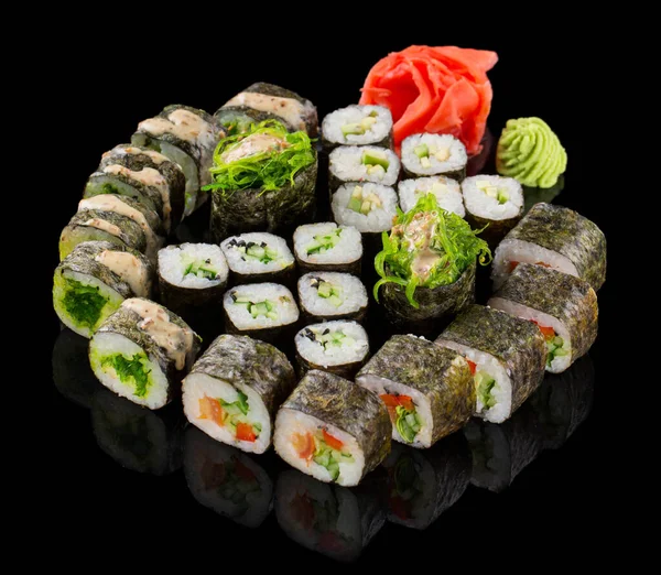 Set di sushi maki assortiti con zenzero e wasabi isolati su sfondo nero con riflesso — Foto Stock