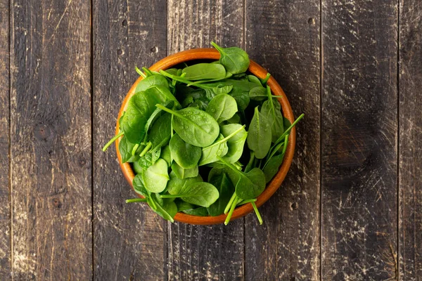 Top view of Spinach leafs in Wooden Bowl on wooden background with Copyspace — Stock Photo, Image