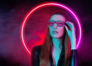 Gözlük takan gelecekçi kadın. Renkli arkaplanda neon ışığı. 