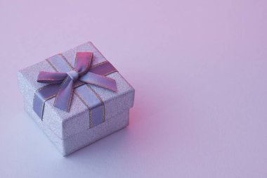 Eflatun arka planda, kopyalanmış parlayan hediye kutusu