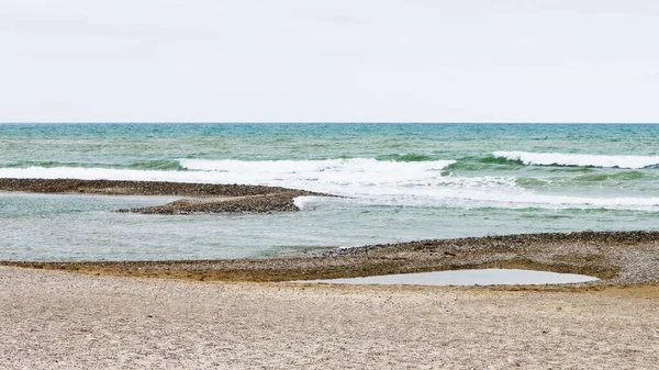 Low tide pools in the beach of Cubelles, Barcelona, Catalonia, Spain. Mediterranean Sea background