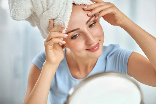 Onun baş sınav sarılmış bir havlu ile genç bir esmer kadın