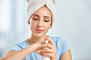 Onun baş putt sarılmış bir havlu ile genç bir esmer kadın