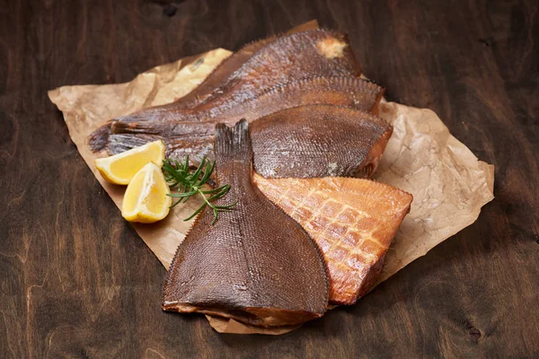 sıcak füme başı kesilmiş dere pisisi limon ve Yeşiller buruşuk kağıt üzerinde