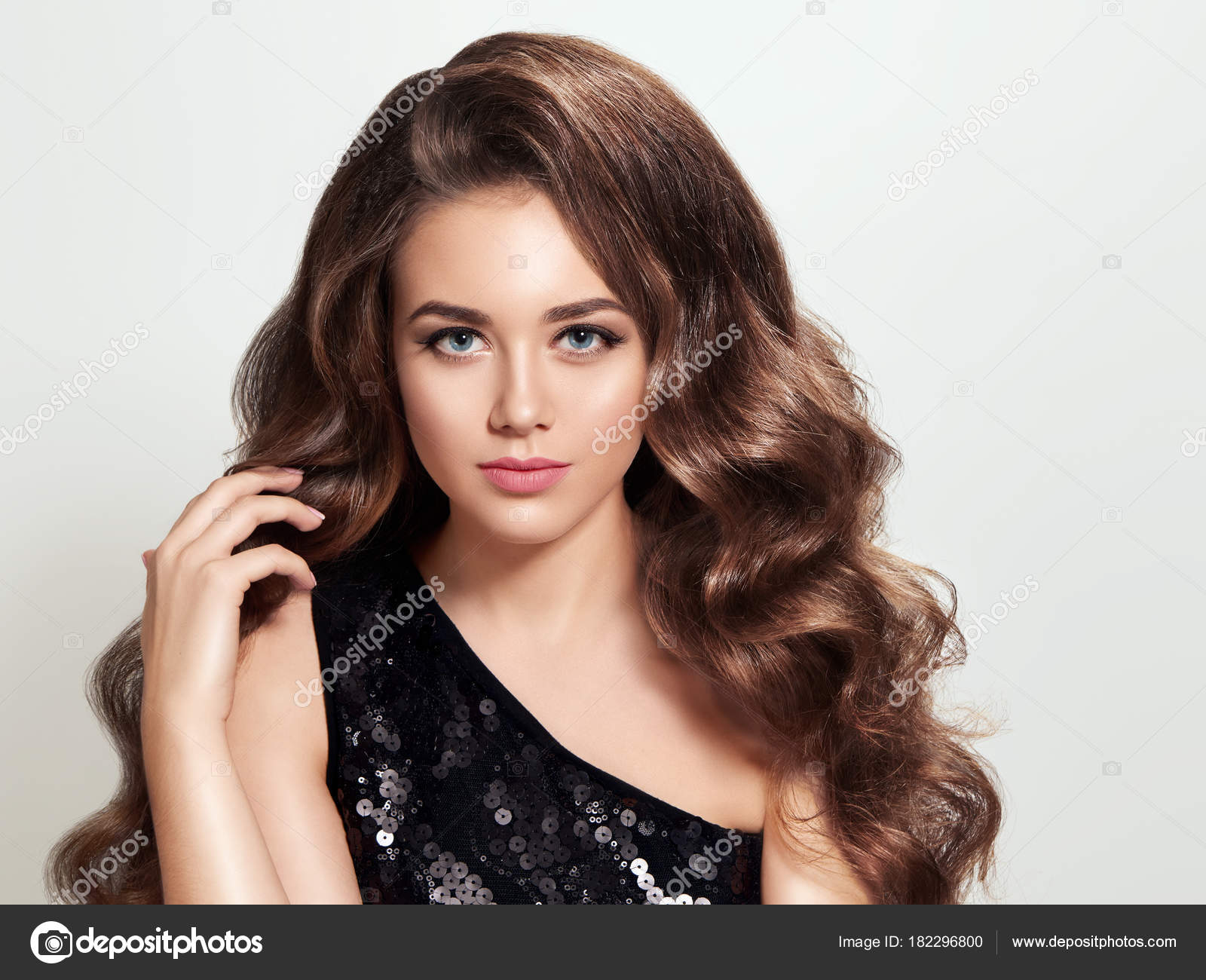 Beautiful brunette girl with long and volume shiny curly hair. S ...