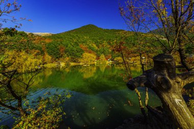  Dağ zirveleriyle çerçevelenmiş güzel dağ gölü berrak suyla mavi gökyüzünün altında.