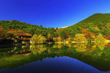  Dağ zirveleriyle çerçevelenmiş güzel dağ gölü berrak suyla mavi gökyüzünün altında.
