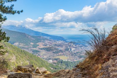 Yalta 'nın dağ manzarası, güzel kar beyazı bulutlar şehre ve Karadeniz' e gölge düşürüyor.
