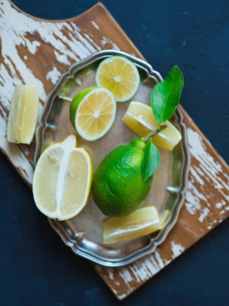 Limonki i cytryny na srebrnej tacy — Zdjęcie stockowe