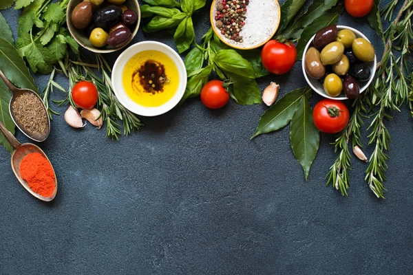 Olives and olive oil on dark stone