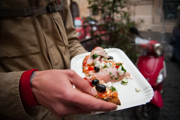 Hand holding a slice of Italian pizza — Stock Photo, Image