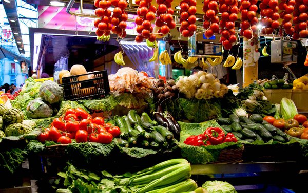 Shopfront with various fresh vegetables at covered street market, Barcelona, Spain