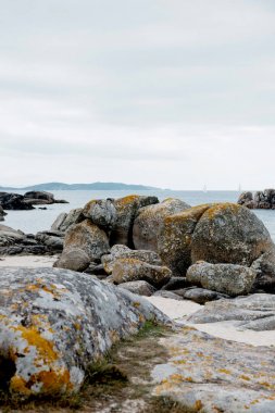 Kıyı kayalar ve deniz kıyısı Yarımadası O Grove, Galiçya, Kuzey İspanya bulutlu gökyüzü. Kıyı şeridi manzara büyük taşlarla 