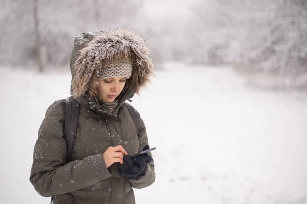 Mulher usando telefone celular na floresta de inverno — Fotografia de Stock