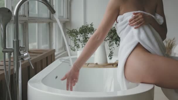 Young Woman Sitting Edge Bathtub Touching Flowing Water — Stock Video