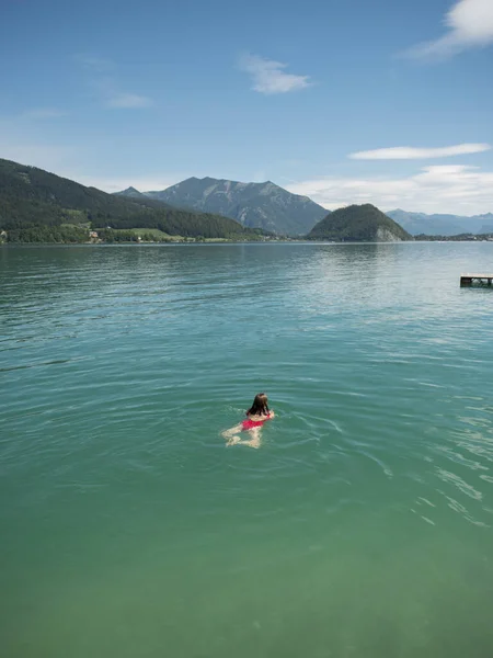 Young woman swimming in lake during sunny day