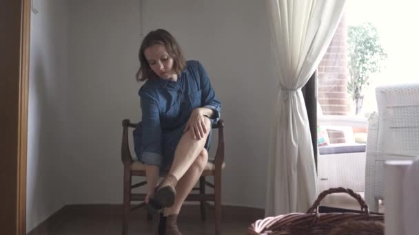 Vrouw Die Een Fauteuil Zit Haar Laarzen Uitdoet — Stockvideo
