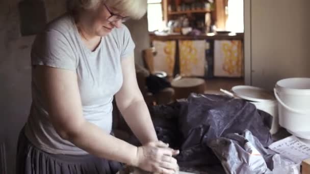 Γυναίκα Αγγειοπλάστρια Ζυμώνει Υγρό Πηλό Ένα Τραπέζι Στο Εργαστήριό Της — Αρχείο Βίντεο