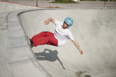 Genç adam dışarıda kaykay numarası yapıyor.