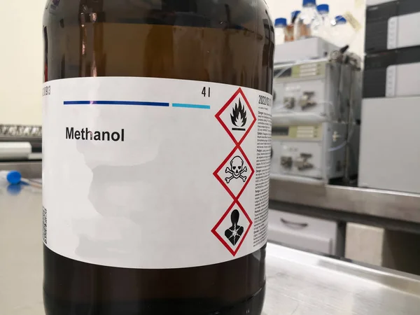 Bernsteinfarbene Glasflasche Zum Blitzschutz Die Methanol Alkohol Und Ein Etikett lizenzfreie Stockbilder