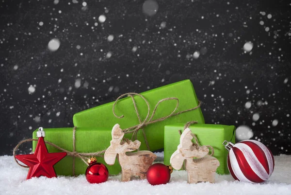 Rote und grüne Weihnachtsdekoration, Schnee, schwarze Zementwand, Schneeflocken — Stockfoto