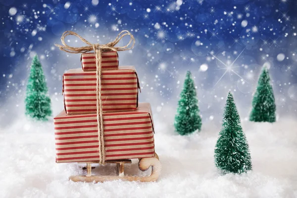 Рождественские санки на снегу с голубым фоном, звезды и снежинки — стоковое фото