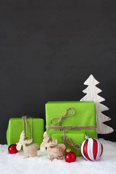 Vertikale rote und grüne Weihnachtsdekoration, schwarze Zementwand, Schnee — Stockfoto