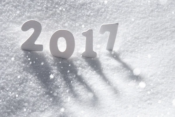 Text 2017 s bílými písmeny na sněhu, sněhové vločky — Stock fotografie