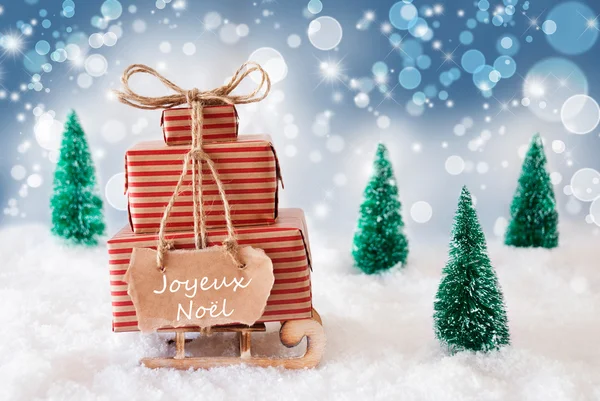 Saně na modrém pozadí, Joyeux Noel znamená Veselé Vánoce — Stock fotografie