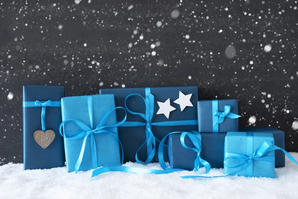 Modré vánoční dárky, černá betonová zeď, sníh, sněhové vločky — Stock fotografie