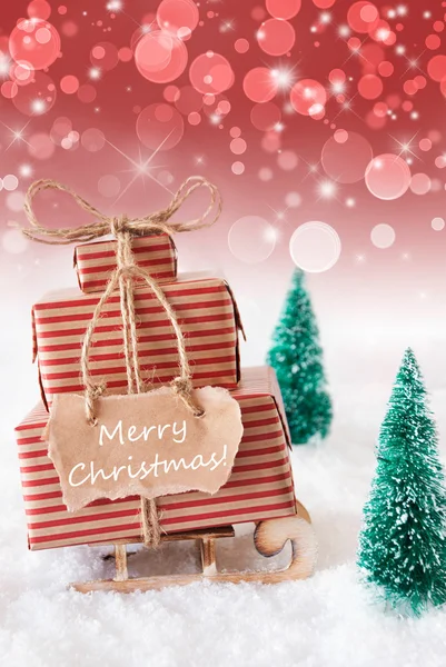 Verticale afbeelding van slee op rode achtergrond, tekst Merry Christmas — Stockfoto