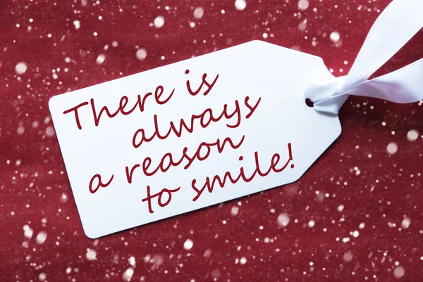Une étiquette sur fond rouge, flocons de neige, citer toujours raison sourire — Photo