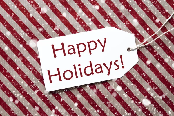 Label op rood papier, sneeuwvlokken, tekst Happy Holidays — Stockfoto